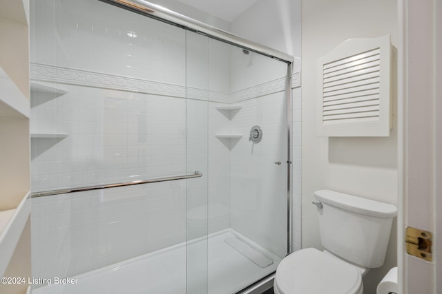 bathroom with an enclosed shower and toilet