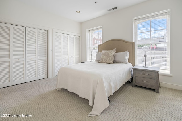 carpeted bedroom with multiple closets