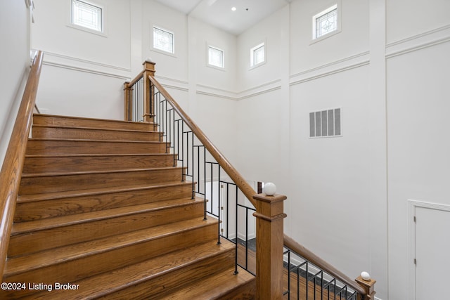 stairs featuring a high ceiling and hardwood / wood-style floors