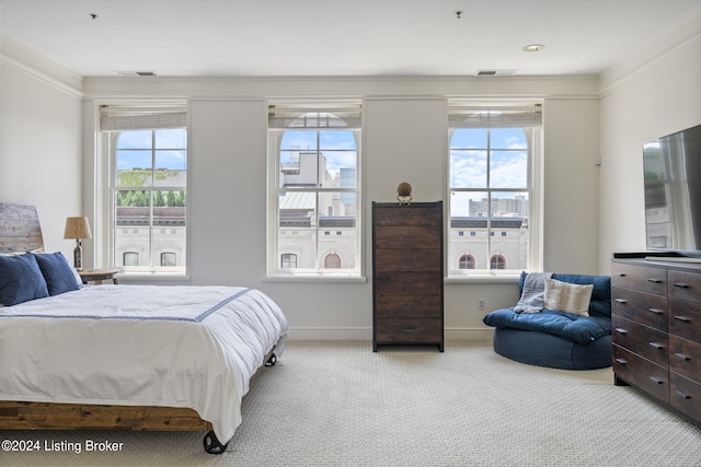 bedroom with crown molding, multiple windows, and light colored carpet