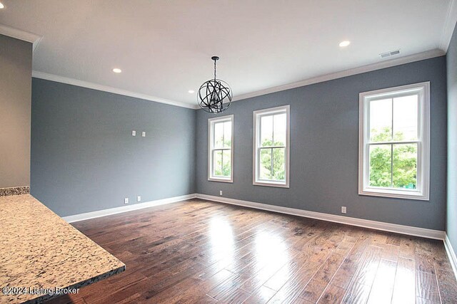 empty room featuring a chandelier, ornamental molding, and dark hardwood / wood-style flooring