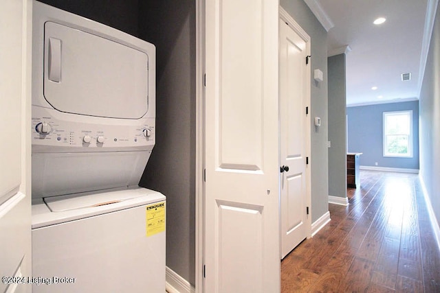 washroom with stacked washing maching and dryer, ornamental molding, and wood-type flooring