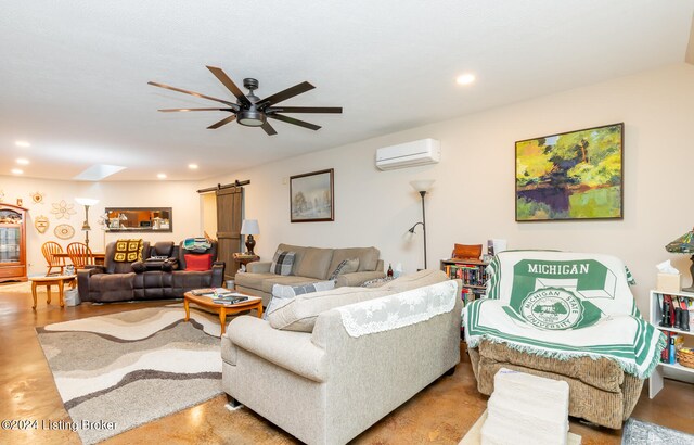 living room with a barn door, ceiling fan, and an AC wall unit