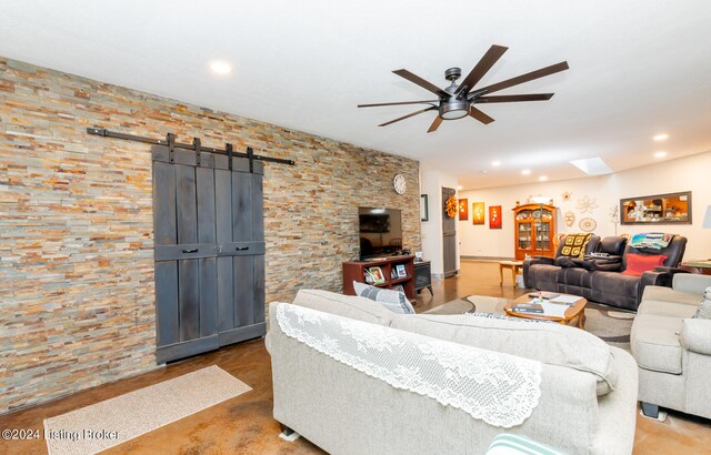 living room featuring a barn door and ceiling fan