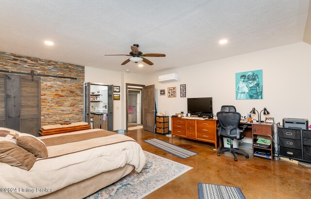 bedroom featuring a wall unit AC, a barn door, ceiling fan, and a textured ceiling