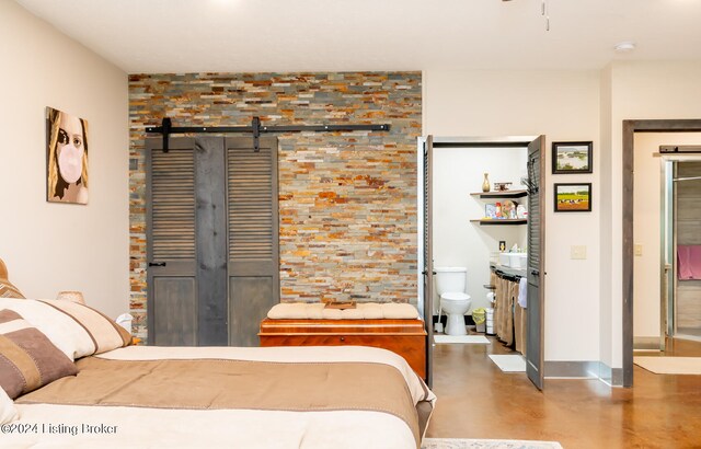 bedroom featuring a barn door and concrete floors