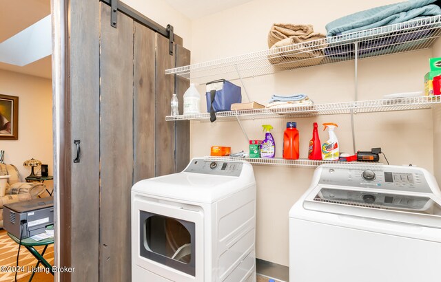 washroom with a barn door and washer and dryer