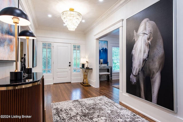 foyer featuring dark hardwood / wood-style flooring, an inviting chandelier, and ornamental molding