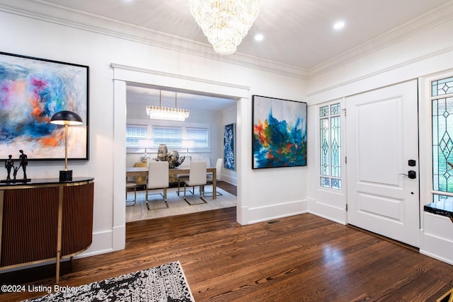 entrance foyer featuring dark wood-type flooring, a chandelier, and ornamental molding