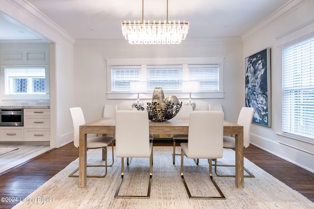 dining area featuring dark hardwood / wood-style flooring, a chandelier, a healthy amount of sunlight, and crown molding