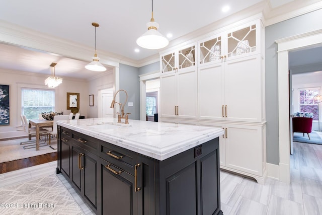 kitchen featuring light hardwood / wood-style flooring, decorative light fixtures, sink, and white cabinets