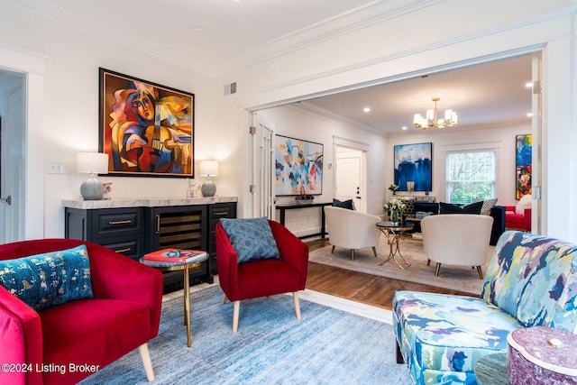 living room with a notable chandelier, crown molding, and light hardwood / wood-style flooring