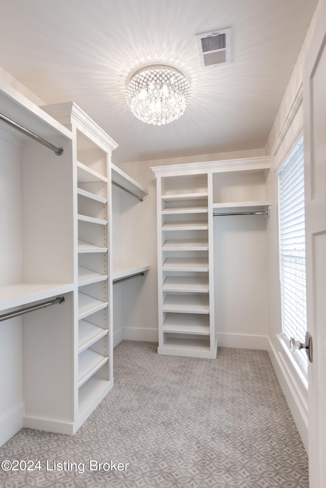 walk in closet featuring a chandelier