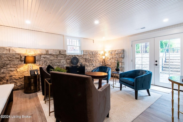 living room with light wood-type flooring, wood ceiling, and french doors