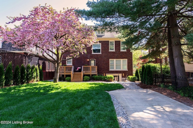 view of front facade featuring a wooden deck and a yard