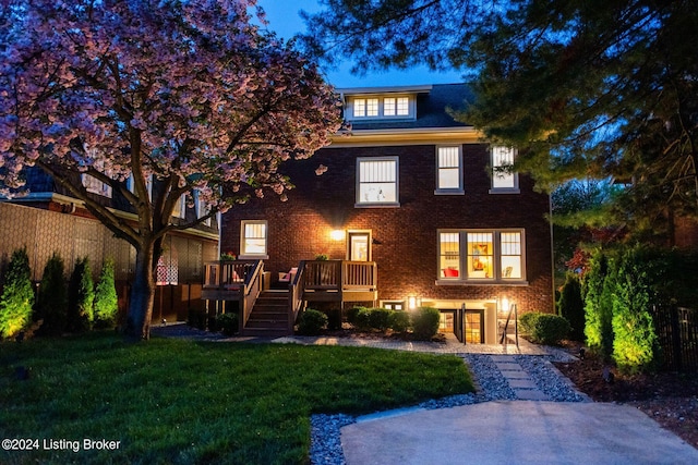 view of front of house featuring a front lawn and a deck