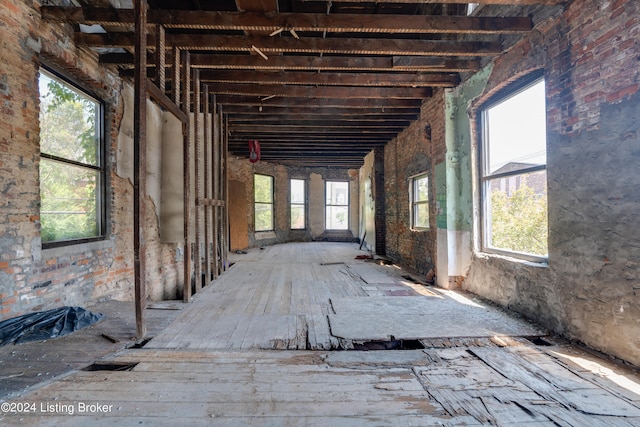 miscellaneous room with brick wall and a wealth of natural light