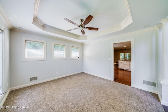 spare room with a tray ceiling, ceiling fan, ornamental molding, and wood-type flooring