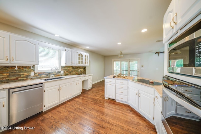 kitchen featuring appliances with stainless steel finishes, hardwood / wood-style floors, sink, and backsplash