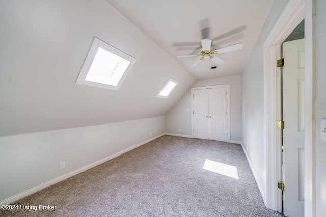 bonus room featuring ceiling fan, carpet, and vaulted ceiling with skylight