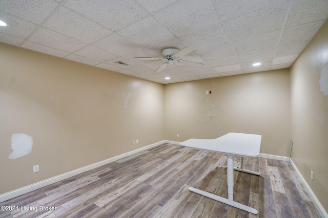 unfurnished room with ceiling fan, wood-type flooring, and a drop ceiling