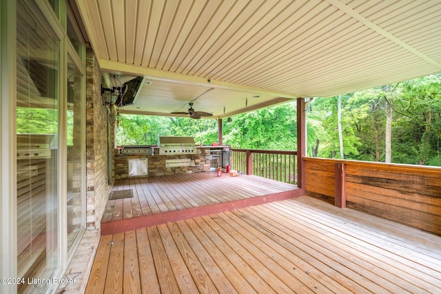 wooden deck with grilling area, ceiling fan, and an outdoor kitchen