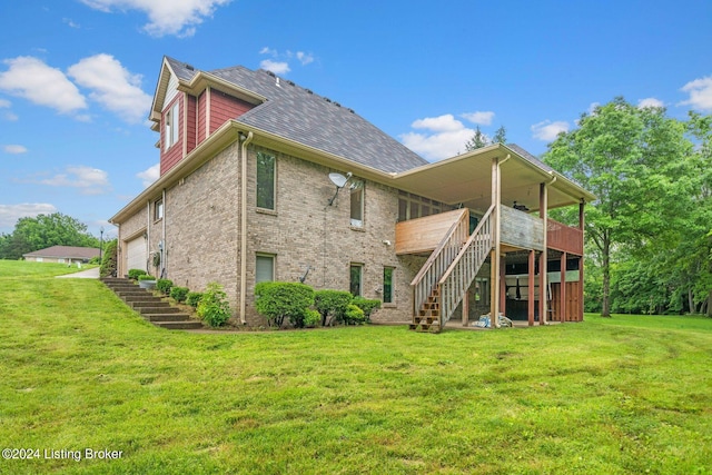 rear view of house with a deck and a lawn