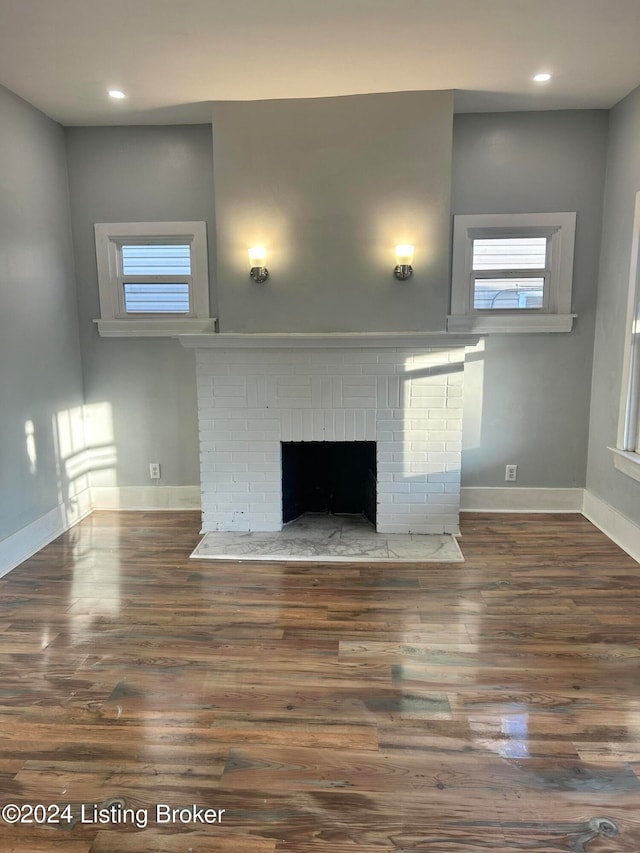 unfurnished living room with a fireplace and dark hardwood / wood-style floors