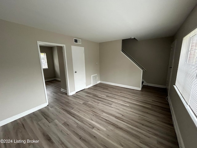 unfurnished living room with wood-type flooring and plenty of natural light