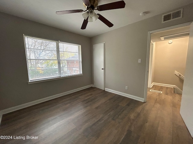 unfurnished bedroom with dark hardwood / wood-style flooring, a closet, and ceiling fan