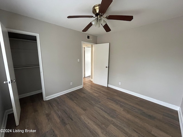 unfurnished bedroom with dark wood-type flooring, ceiling fan, and a closet