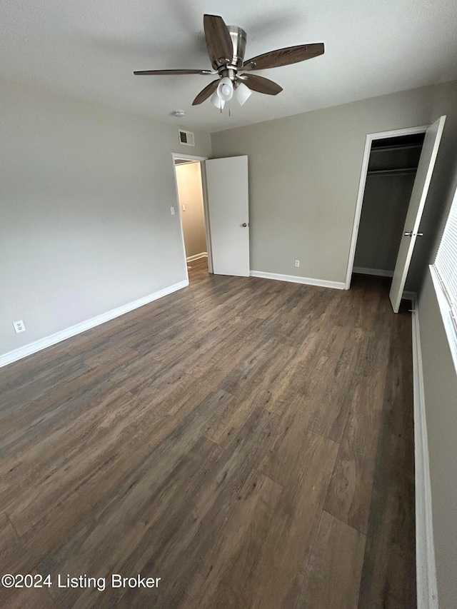 unfurnished bedroom with ceiling fan, dark hardwood / wood-style floors, and a closet