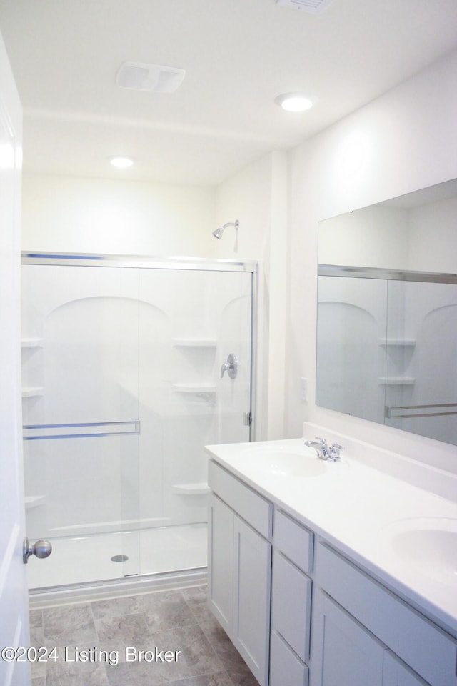 bathroom with vanity and a shower with shower door