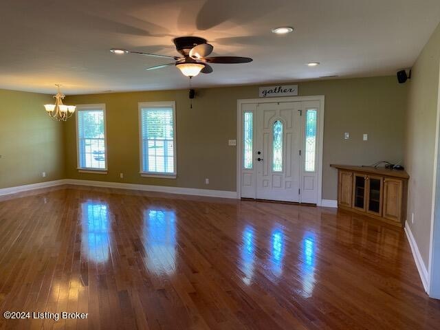 foyer entrance with ceiling fan with notable chandelier and hardwood / wood-style flooring