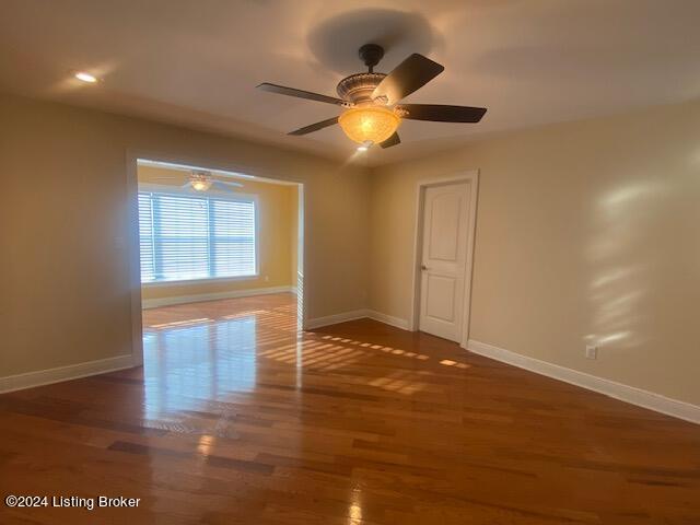 spare room with dark hardwood / wood-style floors and ceiling fan