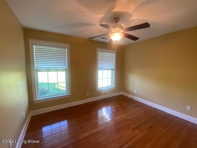 spare room with dark hardwood / wood-style floors and ceiling fan