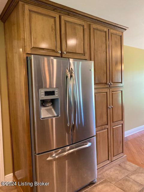 kitchen with stainless steel fridge and light tile floors