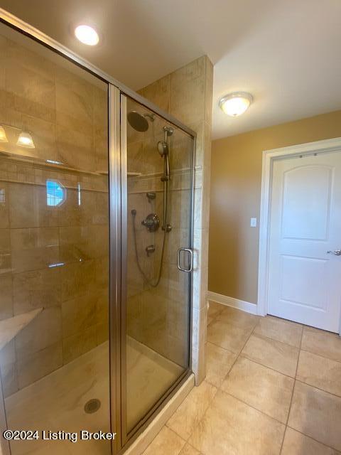 bathroom with tile flooring and an enclosed shower