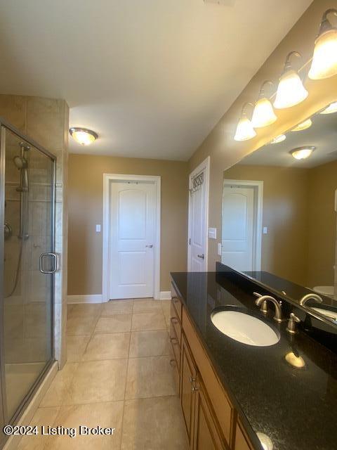 bathroom featuring a shower with shower door, tile floors, and large vanity