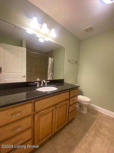 bathroom featuring tile flooring, toilet, and vanity