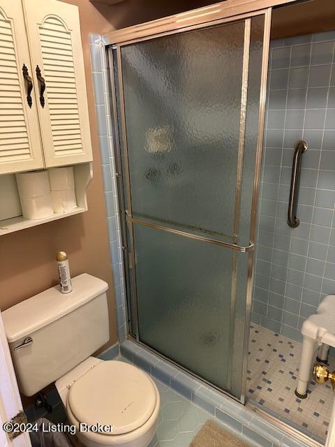 bathroom featuring an enclosed shower and toilet