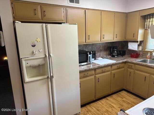 kitchen with white fridge with ice dispenser, sink, backsplash, and light hardwood / wood-style floors