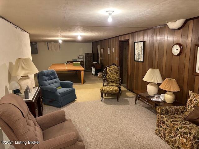 carpeted living room with wooden walls