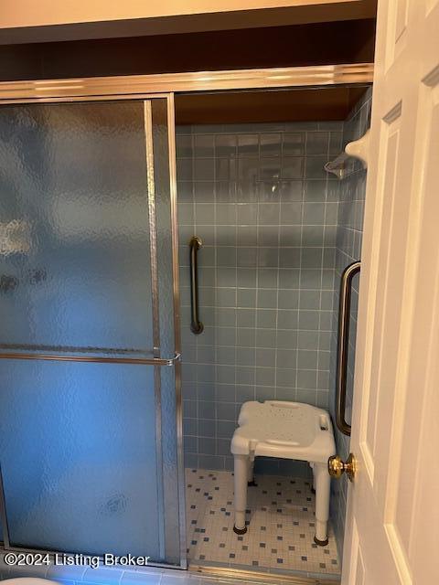 bathroom featuring a shower with shower door and tile patterned flooring