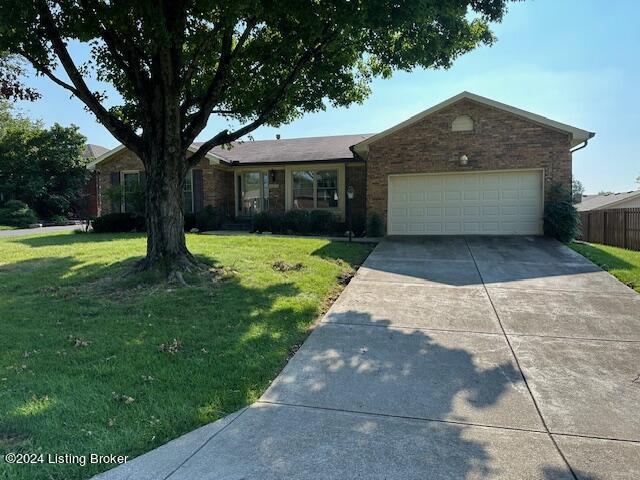 ranch-style home with a garage and a front lawn