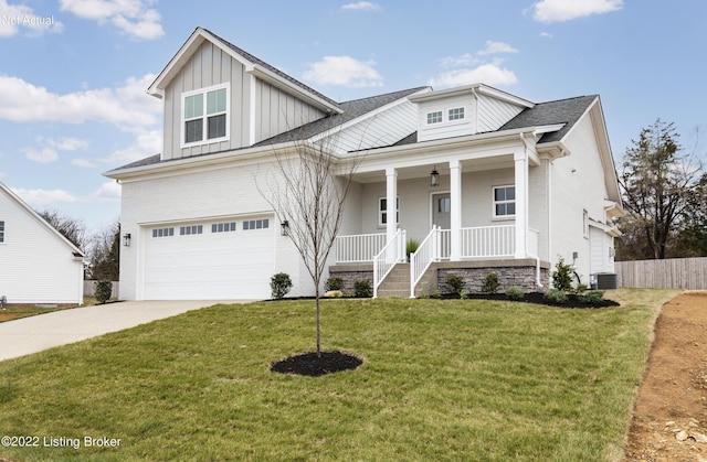 view of front of home featuring a porch, a garage, a front lawn, and cooling unit