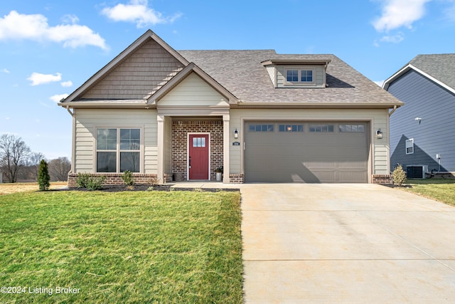 craftsman house featuring cooling unit, a front yard, and a garage