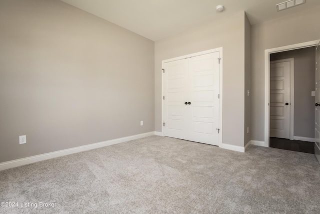 unfurnished bedroom with a closet and carpet flooring