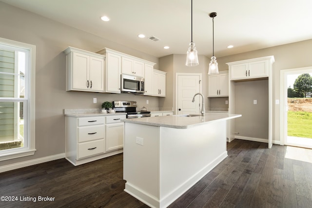 kitchen with stainless steel appliances, sink, a center island with sink, and white cabinets