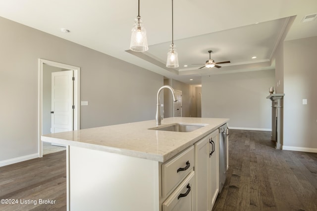 kitchen with sink, light stone counters, pendant lighting, a kitchen island with sink, and white cabinets